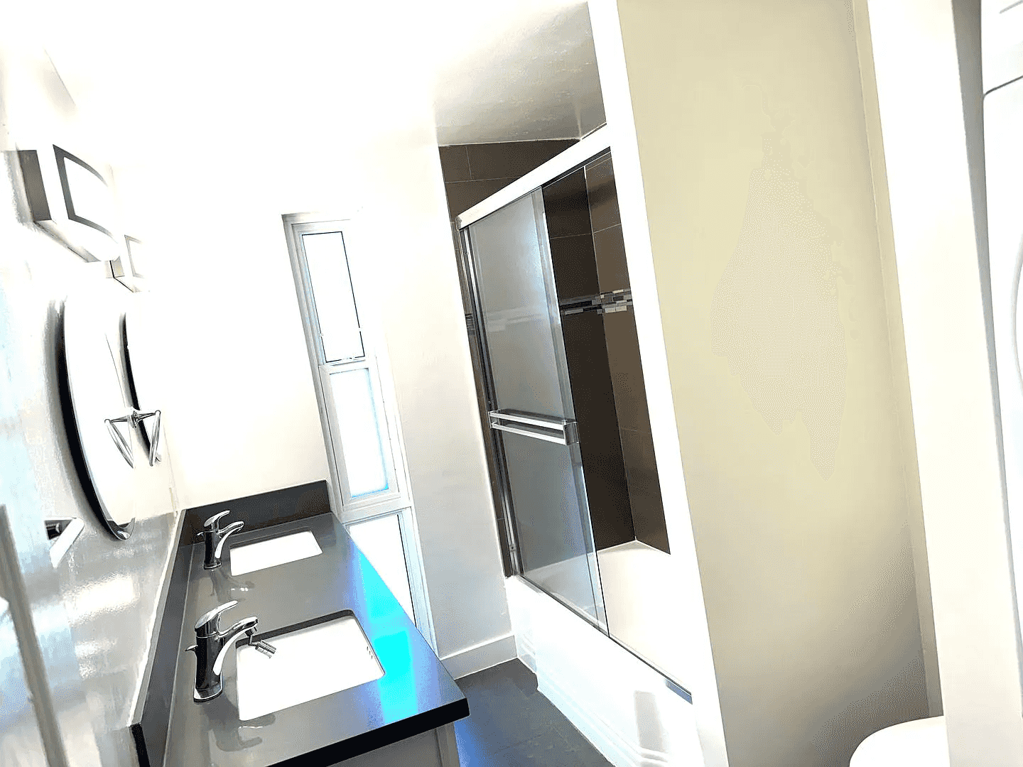 renovated bathroom with dual vanity and glass shower